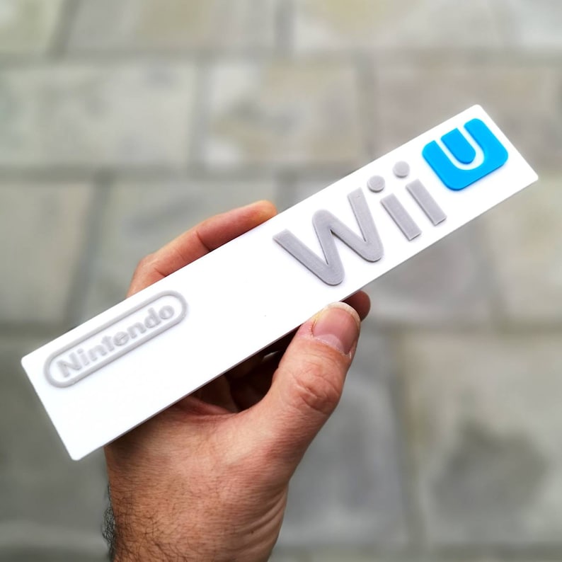 May include: A white Nintendo Wii U console with the Nintendo logo and the words "Wii U" in gray and blue lettering.