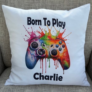 May include: White pillow with a colorful video game controller graphic and the text "Born To Play Charlie".