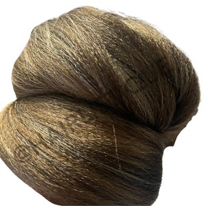 May include: A brown and grey hair bun extension. The hair is long and thick, and it is tied into a bun shape.