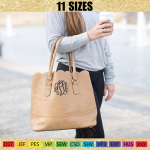 May include: A tan tote bag with a scalloped top edge and gold-colored hardware. The bag features a black monogram and two handles. The text "11 SIZES" is at the top. The bag is being held by a person.