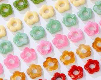 May include: Assortment of colorful plastic flower-shaped beads with a hole in the center. The beads are in various colors, including pink, green, yellow, orange, and red.