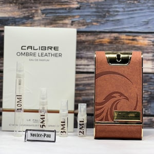 May include: A set of perfume samples in various sizes, including 2 ml, 3 ml, 5 ml, and 10 ml. The samples are in clear glass bottles with black labels and black caps. The bottles are arranged on a white surface. The perfume is called "Calibre Ombre Leather Eau de Parfum".
