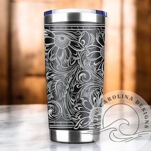 Peut inclure: Un gobelet en acier inoxydable noir et blanc avec un motif floral. Le gobelet a un couvercle noir et un logo blanc qui dit "CAROLINA DESIGNS".