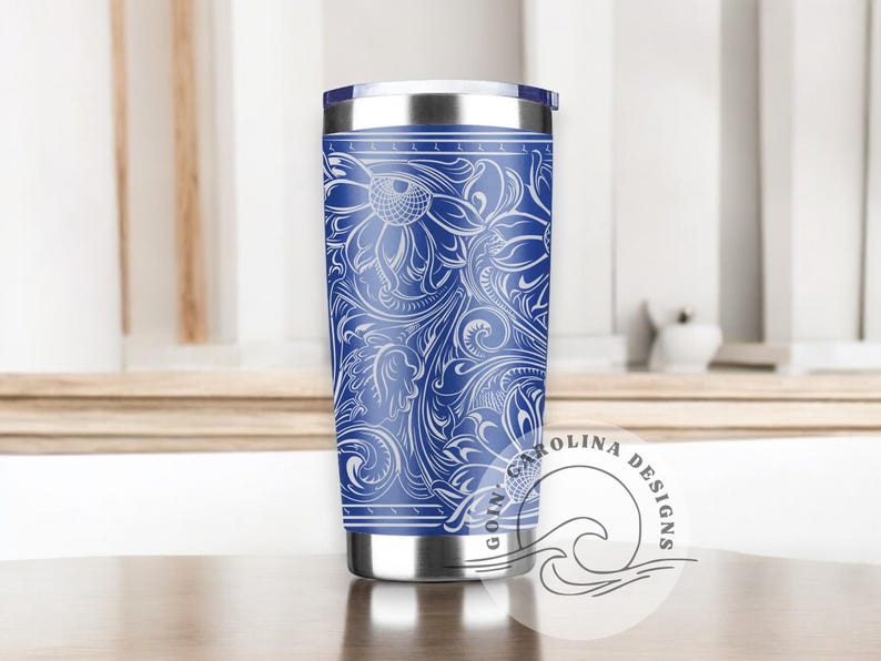 Peut inclure: Un gobelet isotherme en acier inoxydable bleu avec un motif floral blanc. Le gobelet est dot&eacute; d'un couvercle et est parfait pour garder les boissons froides ou chaudes.