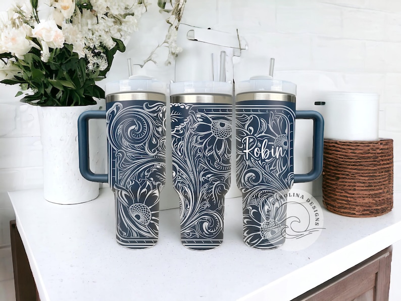 Peut inclure: Trois gobelets en acier inoxydable avec un motif floral bleu et blanc. Les gobelets ont un couvercle avec une paille et une poign&eacute;e. Les gobelets sont personnalis&eacute;s avec le nom "Robin".