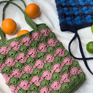 May include: Two crocheted tote bags, one in green and pink and the other in blue. Both bags have a checkered pattern.
