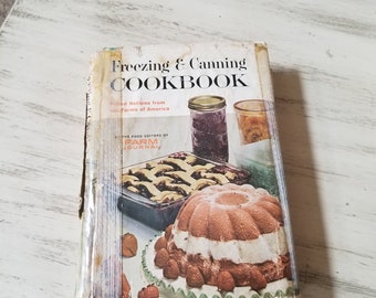 May include: A vintage cookbook titled "Freezing & Canning Cookbook" with the text "Tried Recipes from the Farms of America" and a photo of a cake and jars of preserves on the cover.