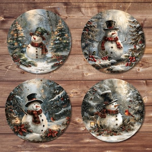 May include: Four round decorative coasters featuring winter snowman scenes. Each coaster depicts a snowman wearing a hat and scarf, set in a snowy forest with pine trees and red berries. The coasters are set against a wooden background.