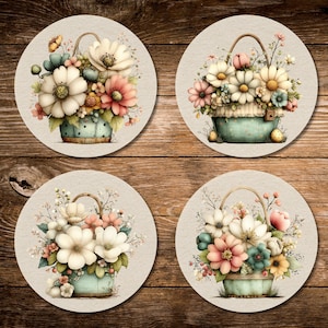 Può includere: Quattro sottobicchieri rotondi con disegni di cestini floreali. Ogni sottobicchiere presenta un cestino azzurro pieno di fiori bianchi, rosa e gialli. I sottobicchieri sono su uno sfondo di legno, creando un'estetica rustica.