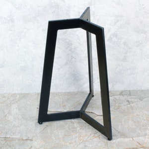 Puede incluir: Base de mesa de metal negro con forma triangular y tres patas. La base está hecha de metal resistente y tiene un diseño elegante y moderno.