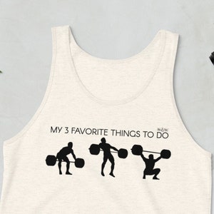 May include: A white tank top with the text "My 3 favorite things to do" and three silhouettes of people lifting weights.