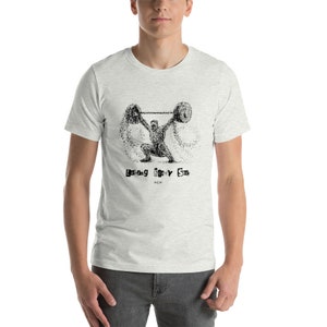 May include: A heather grey t-shirt with a black and white illustration of a person lifting weights. The text "Lifting Heavy Stuff" is printed below the illustration.