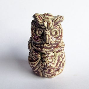 May include: A ceramic owl figurine with brown and white glaze. The owl has a detailed design and a round body.