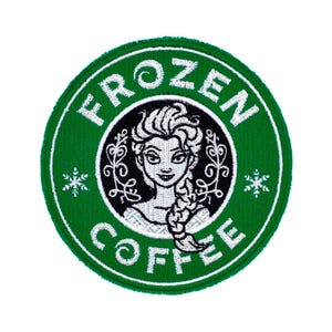 Op de afbeelding: Een ronde geborduurde patch met een groene rand en de witte tekst FROZEN COFFEE. Het midden bevat een zwarte cirkel met een witte illustratie van een personage met een gevlochten kapsel, geflankeerd door witte decoratieve rankpatronen.