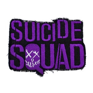 Könnte beinhalten: Lila und schwarzer gestickter Patch mit dem Text "Suicide Squad" und einer lila Sprechblase mit einem weißen Totenkopf und gekreuzten Knochen.