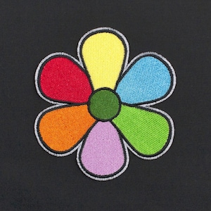 Peut inclure: Un écusson brodé en forme de fleur composé de six pétales arrondis de couleur jaune, bleu clair, vert lime, violet clair, orange et rouge, entourant un centre circulaire vert foncé, le tout bordé d'un fin contour noir et blanc.