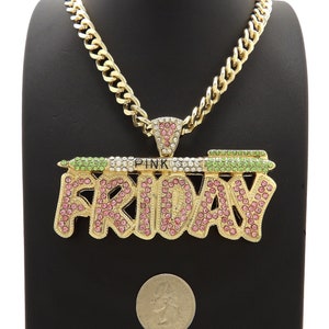 May include: Gold chain necklace with a large pendant that says "PINK FRIDAY" in gold letters with pink and green rhinestones.