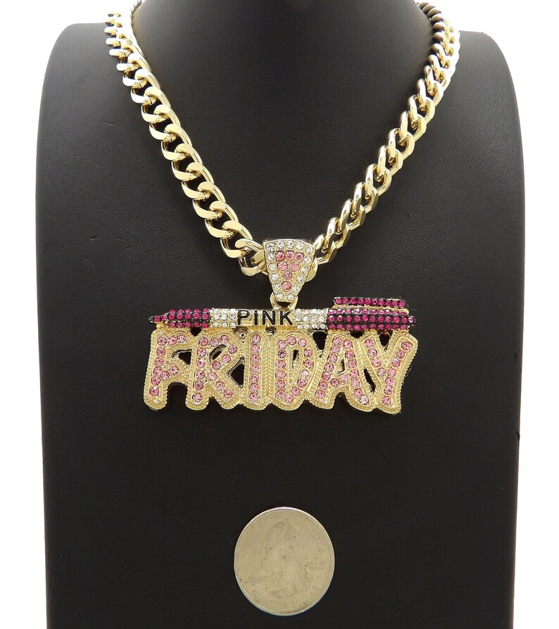 May include: Gold chain necklace with a large pendant that says "PINK FRIDAY" in gold letters with pink rhinestones.