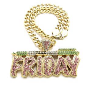 May include: Gold chain necklace with a large pendant that says "FRIDAY" in gold letters with pink and green rhinestones. The pendant also has the word "PINK" in smaller letters.