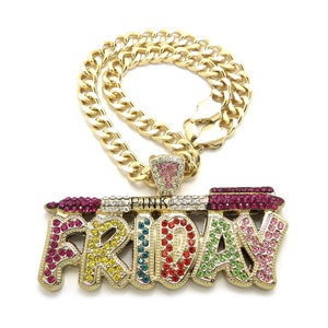 May include: Gold chain necklace with a pendant that says "FRIDAY" in colourful rhinestones. The pendant also features a pink lipstick with rhinestones.