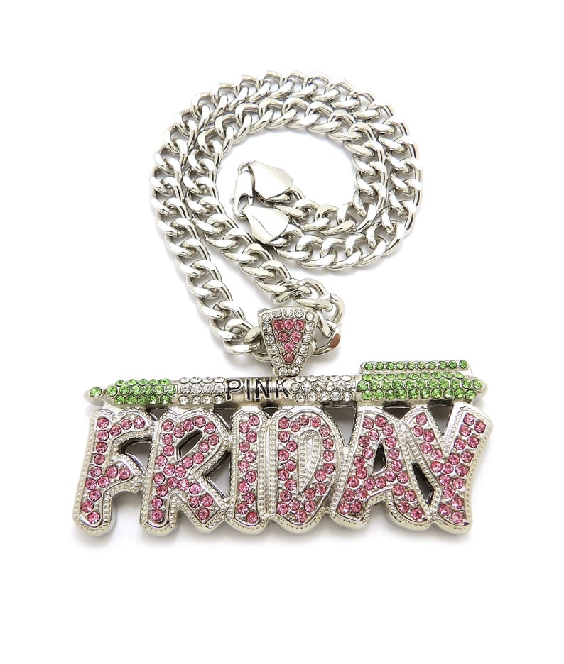 May include: A silver chain necklace with a large pendant that says "PINK FRIDAY" in pink and green rhinestones.