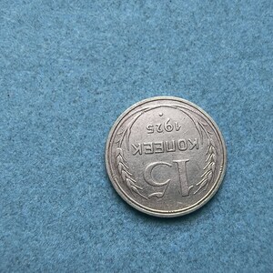 May include: A silver coin with the inscription "1 КОПЕЕК 1962" surrounded by a wreath of wheat.