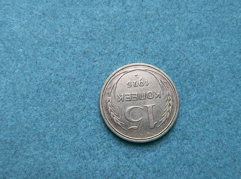 May include: A silver coin with the inscription "1 КОПЕЕК 1962" surrounded by a wreath of wheat.