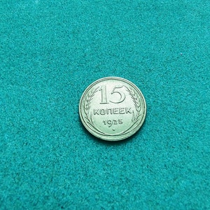 May include: A silver 15 kopeек coin from 1925, featuring a wheat design around the edge.
