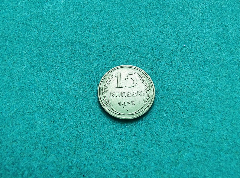 May include: A silver 15 kopeек coin from 1925, featuring a wheat design around the edge.