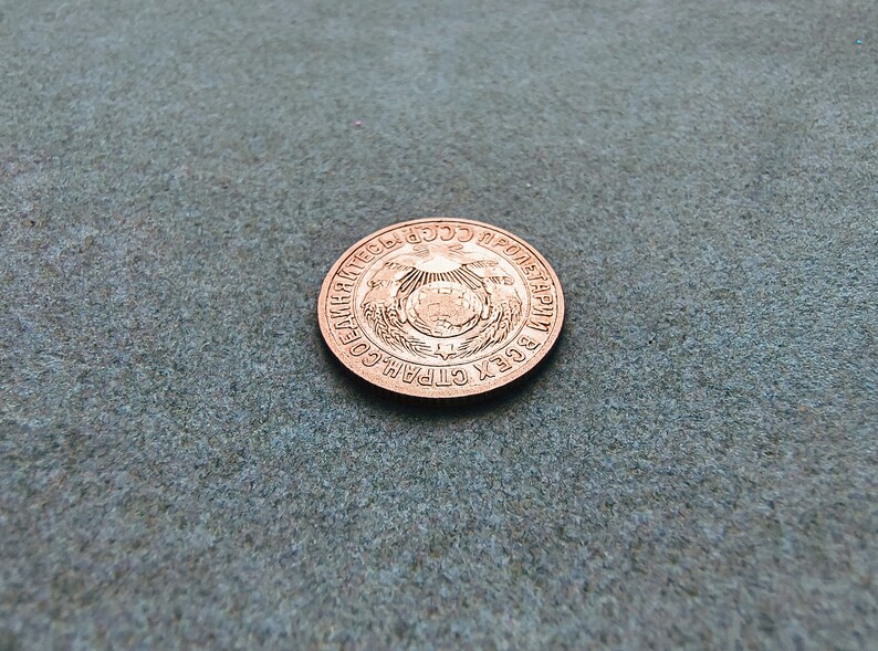 May include: A copper-colored coin with the inscription "СССР ВСЕХ СТРАН ПРОЛЕТАРИИ СОЕДИНЯЙТЕСЬ" around the edge.