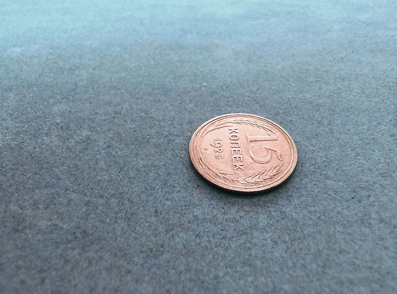 May include: A copper-colored coin with the inscription "1 копейка 1925" (1 kopeck 1925) in Cyrillic script.