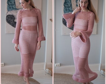 Può includere: Un abito maxi in crochet rosa con maniche a campana e un orlo svasato. L'abito è realizzato con un punto largo e aperto.