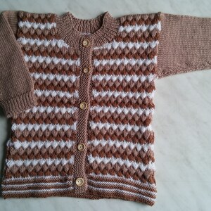 May include: A brown and white striped knitted cardigan with wooden buttons.