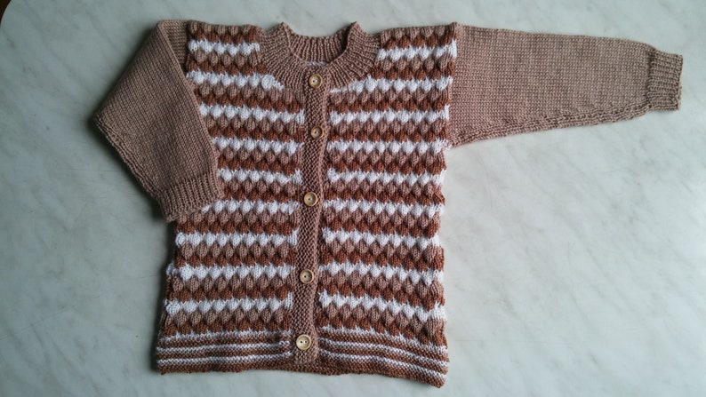 May include: A brown and white striped knitted cardigan with wooden buttons.