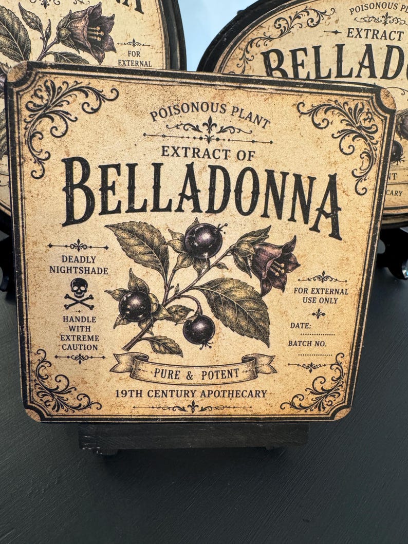 May include: A square sign with a beige, aged background featuring black text and a botanical illustration of a belladonna plant. The text reads: Poisonous Plant, Extract of Belladonna, Deadly Nightshade, Handle with Extreme Caution, For External Use Only, Pure & Potent, 19th Century Apothecary, Date, and Batch No.