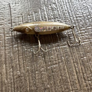May include: A white ceramic mug with a black handle and the text "But First, Coffee" in a black, handwritten-style font. The mug is on a white surface.