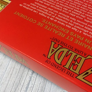 May include: A red box with the words "The Legend of Zelda" and "A Link to the Past" in gold lettering. The box is for a video game.