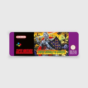 Könnte beinhalten: Eine violette Super Nintendo-Spielkassette mit einem Etikett, auf dem ein Ritter in Rüstung gegen einen Ghul kämpft. Der Text auf dem Etikett lautet "Super Ghoul's & Ghosts".