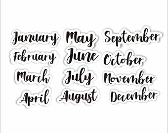 May include: Twelve black and white stickers with the names of the months of the year written in a cursive font.