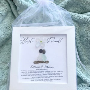 May include: White framed artwork with a sea glass and shell design. The artwork features the text "Best Friend" and "Sabrina & Melanie". The text below the names reads "An irreplaceable person who means the world to you..."