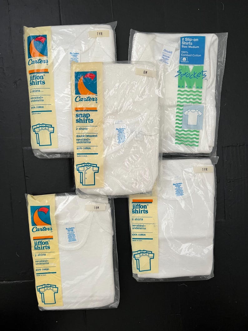 Puede incluir: Un conjunto de cinco paquetes de camisetas interiores para beb&eacute;s y ni&ntilde;os peque&ntilde;os de la marca Carter's. Los paquetes son blancos con detalles azules y rojos. Cada paquete contiene dos camisetas y est&aacute; etiquetado con la talla y el tipo de camiseta. Las camisetas est&aacute;n hechas de 100% algod&oacute;n.