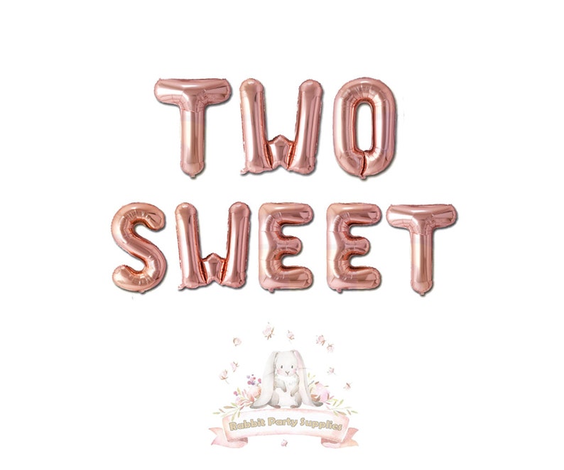 Op de afbeelding: Rosegouden folieballonnen met de tekst "TWO SWEET" op een witte achtergrond. De ballonnen zijn in twee rijen gerangschikt. Onderaan staat een logo van "Rabbit Party Supplies".