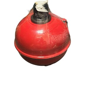 May include: A red, spherical buoy with a black top, wrapped in clear plastic. The buoy has a chain attached and appears to be new. The buoy is designed for marine use.
