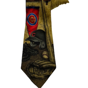 Puede incluir: Corbata con temática de béisbol con el logotipo de los Cubs, bate de béisbol, casco, pelota, guante y tacos. La corbata tiene un fondo beige con detalles en marrón y rojo. Un accesorio único para los fanáticos del béisbol.
