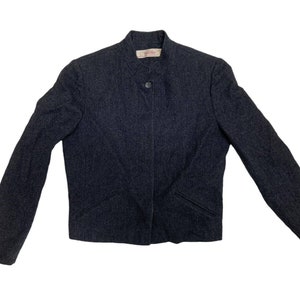 May include: A dark grey blazer with a button fastening and a small label on the collar that says "Cigala".