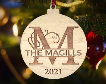May include: A wooden Christmas ornament with a large letter "M" and the text "THE MAGILLS 2021" engraved on it.
