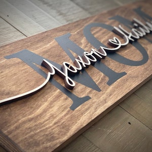 May include: A wooden sign with the word "MOM" in black paint and the phrase "you are my everything" in cursive script in brown wood.