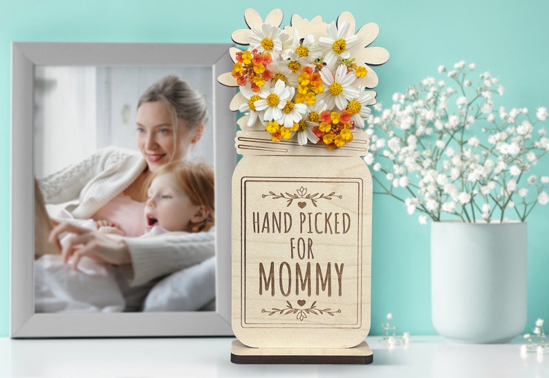 May include: Wooden cutout of a mason jar with flowers and the text "HAND PICKED FOR MOMMY".