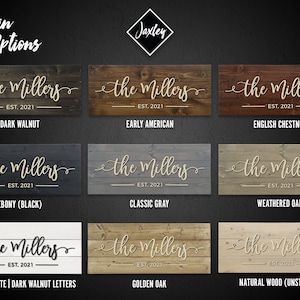 Puede incluir: Nueve opciones diferentes de tinte para madera para un letrero personalizado. El letrero dice "the Millers EST. 2021" en una fuente cursiva. Las opciones de tinte son: Nogal oscuro, Americano antiguo, Casta&ntilde;o ingl&eacute;s, &Eacute;bano (negro), Gris cl&aacute;sico, Roble envejecido, Blanco antiguo | Letras de nogal oscuro, Roble dorado y Madera natural (sin te&ntilde;ir).