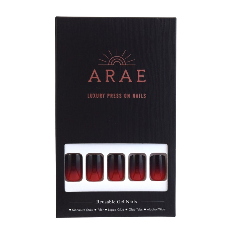 Squoval shaped nails in an ombre design. The tips are black and move to a cherry red at the base. The nails are a rounded square. They come in a Black box. The box includes a Manicure stick, Nail file, Liquid Glue and Glue Tabs and an alcohol wipe.